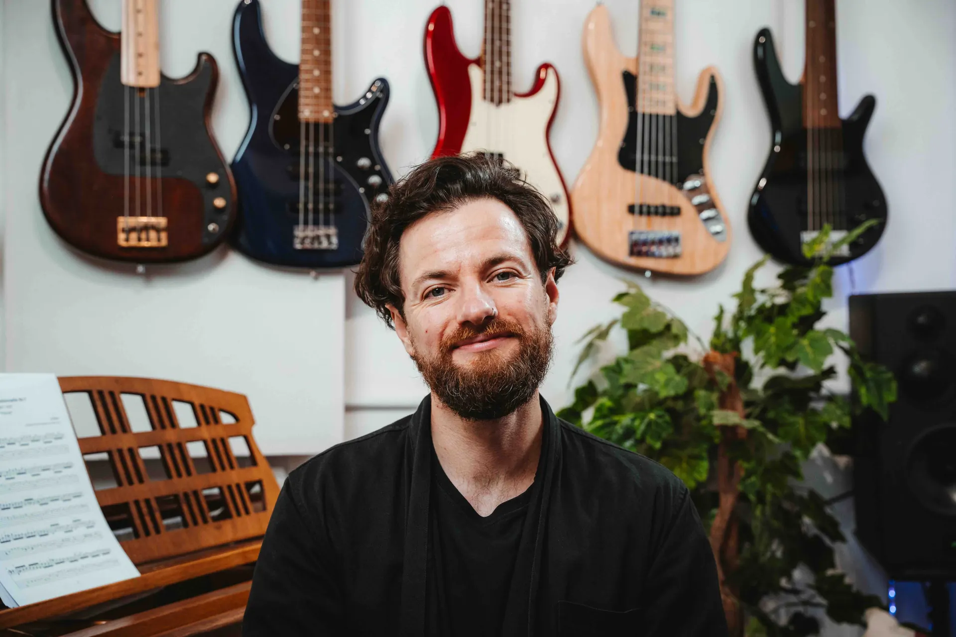 Jack Elliot in the studio with a wall of bass guitars behind him